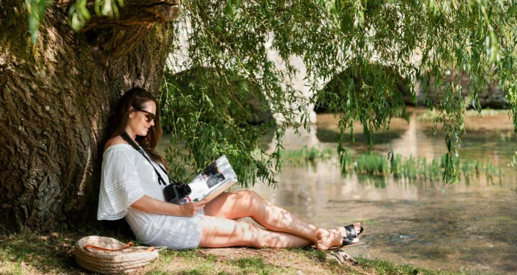The Benefits of the Great Outdoors woman reading under tree